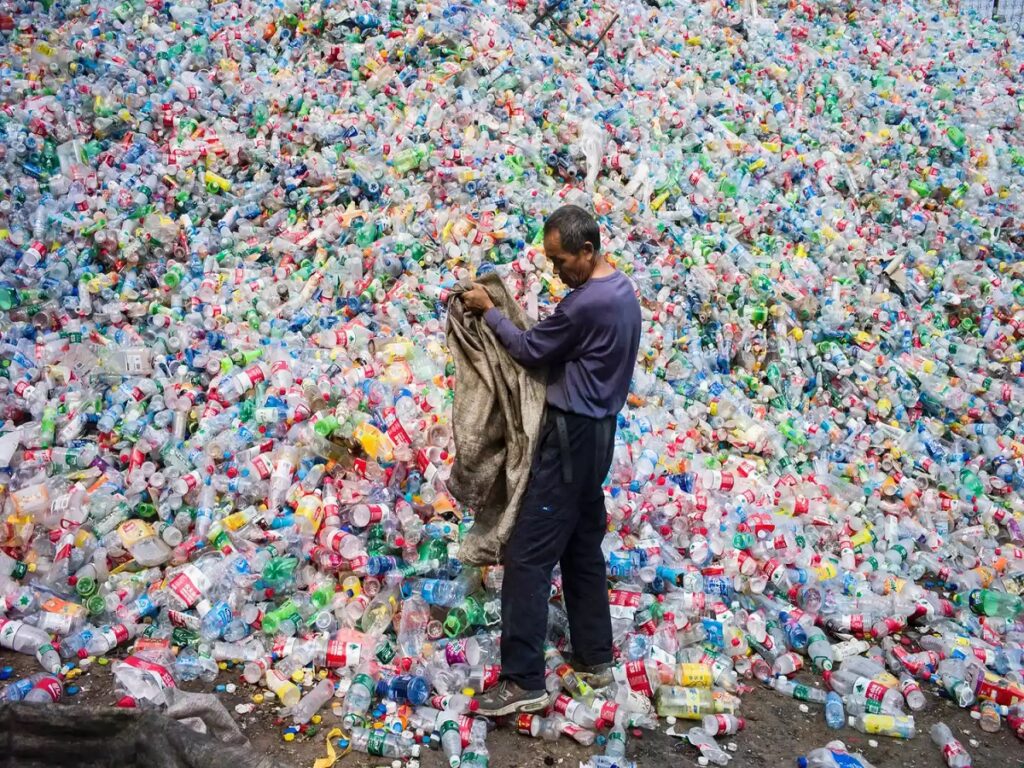 On September 17, 2015, a photograph captured a Chinese laborer diligently sorting through a vast collection of plastic bottles for recycling in Dong Xiao Kou village, located just outside Beijing.